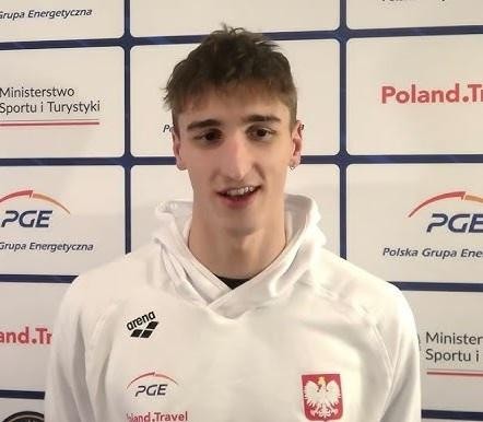 Zbliżenie na Ksawerego Masiuka podczas wyścigu stylem grzbietowym, ukazujące jego technikę i determinację.