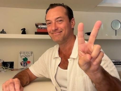 Jude Law w dynamicznej scenie, w kostiumie jednej ze swoich ikonicznych ról filmowych, z intensywnym wyrazem twarzy.