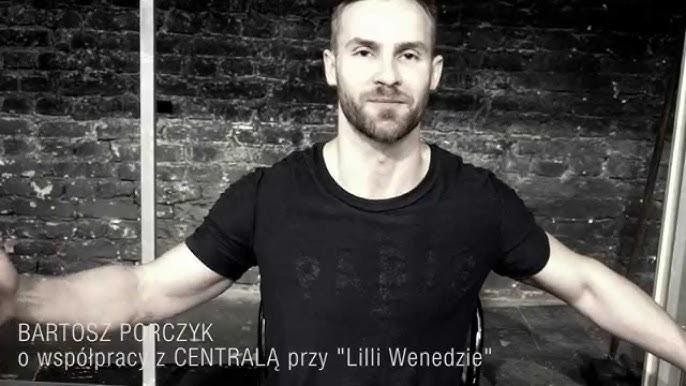 Bartosz Porczyk na scenie teatralnej, w trakcie występu, z intensywnym oświetleniem podkreślającym dramaturgię roli.
