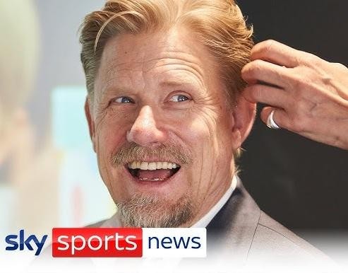 Peter Schmeichel jako komentator sportowy, wpatrzony w obiektyw, w tle subtelnie zarysowane studio telewizyjne.