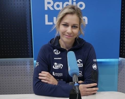 Aleksandra Mirosław trenująca na 15-metrowej ściance wspinaczkowej w hali sportowej Lubelskiego Uniwersytetu Medycznego, ukazująca skalę miejsca treningowego.