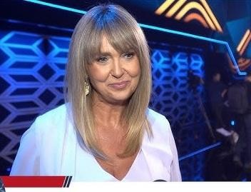 Ewa Wachowicz w kuchni, z uśmiechem przygotowująca potrawę, symbolizująca jej pasję do gotowania i program