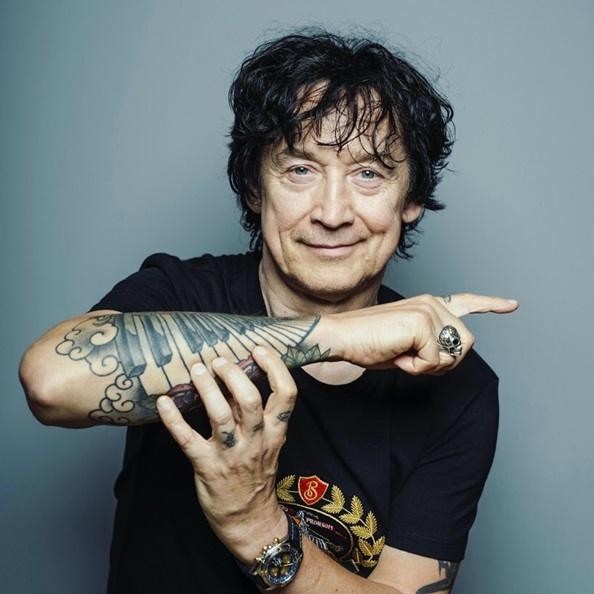 Czarno-białe zbliżenie twarzy Jana Borysewicza, ukazujące jego intensywne spojrzenie i charakterystyczny wyraz rockowego muzyka.