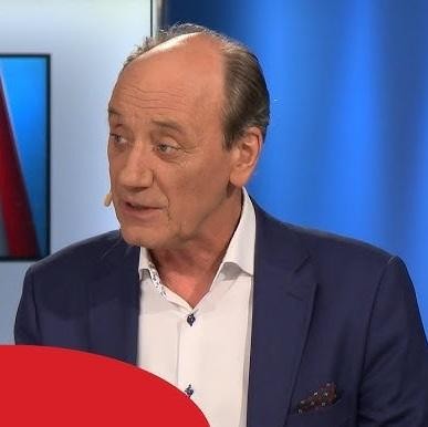 Dariusz Szpakowski, pełen pasji, komentujący mecz piłkarski na stadionie.