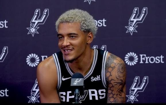 Jeremy Sochan w dynamicznej akcji na boisku NBA, wykonujący rzut lub wsad dla San Antonio Spurs.