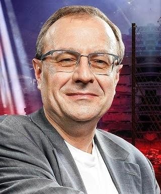 Stos książek i artykułów naukowych, symbolizujący dorobek pisarski Antoniego Dudka w dziedzinie historii i politologii.