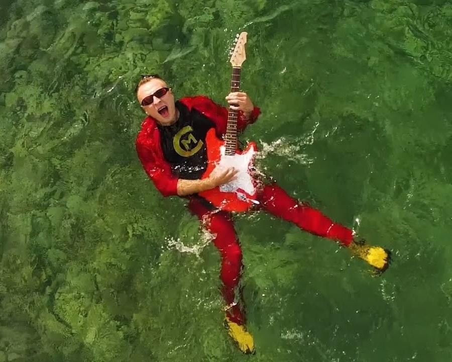 Czadoman podczas energicznego występu na scenie, z mikrofonem i dynamicznym oświetleniem.