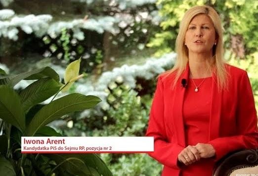 Iwona Arent w dynamicznej pozie podczas wystąpienia w Sejmie, symbolizująca jej aktywność polityczną.