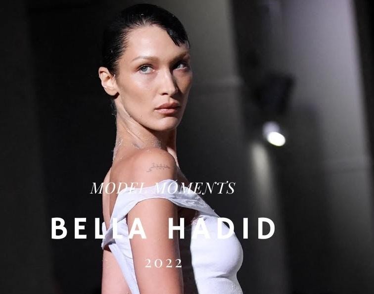 Bella Hadid, modelka, aktywnie korzystająca z telefonu, w tle stylowe otoczenie.
