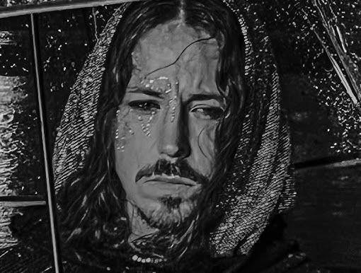 Michał Szpak na scenie podczas występu, z mikrofonem, długimi włosami i teatralnym oświetleniem, ukazujący jego pasję i charyzmę.
